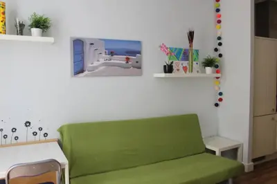 a living room with a green couch and a table at Bonito apartamento Cádiz centro in Cádiz