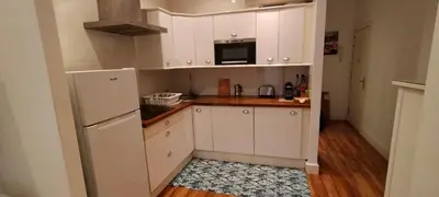 a kitchen with white cabinets and a refrigerator at Bonito apartamento Cádiz centro in Cádiz