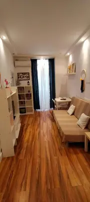 a living room with a couch and a wooden floor at Bonito apartamento Cádiz centro in Cádiz
