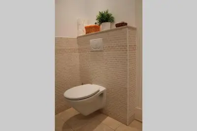 a bathroom with a toilet in a tiled wall at Bonito apartamento Cádiz centro in Cádiz