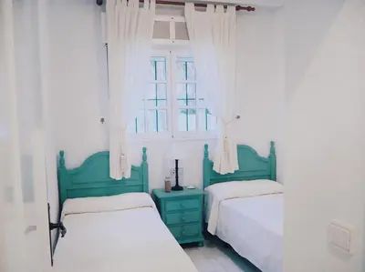 a bedroom with two beds and a window at Apartamento La Barrosa, Chiclana in Chiclana de la Frontera
