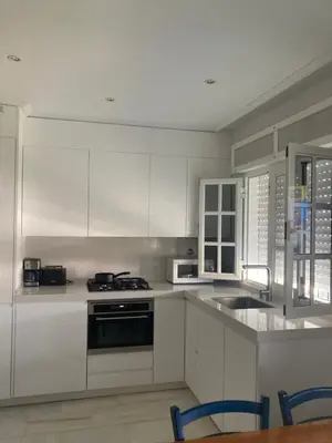 a kitchen with white cabinets and a sink at Apartamento La Barrosa, Chiclana in Chiclana de la Frontera