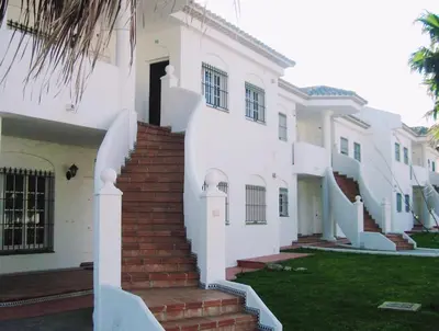 a white house with stairs in front of it at Apartamento La Barrosa, Chiclana in Chiclana de la Frontera