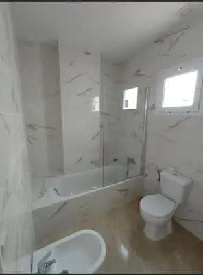 a bathroom with a toilet and a tub and a sink at Apartamentos Turísticos La Terraza* in Las Cabezas de San Juan