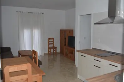 a kitchen and living room with a table and a dining room at Apartamentos Turísticos La Terraza* in Las Cabezas de San Juan
