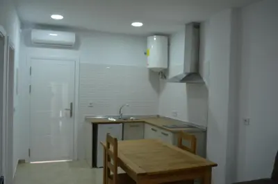 a kitchen with a wooden table and a sink at Apartamentos Turísticos La Terraza* in Las Cabezas de San Juan
