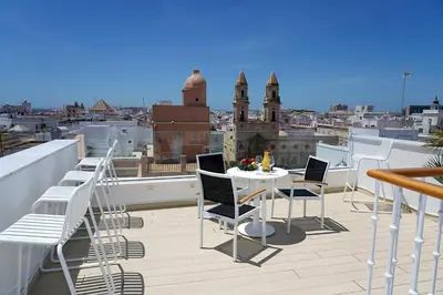 a balcony with a table and chairs on a roof at Plaza Mina Suites - Adults Recommended by Luxury Suites Cadiz in Cádiz
