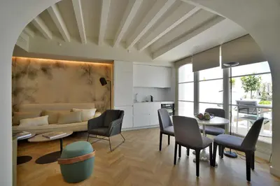 a living room with a couch and a table and chairs at Plaza Mina Suites - Adults Recommended by Luxury Suites Cadiz in Cádiz