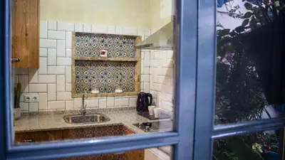 a kitchen with a sink and a tile wall at Casa Arco de la Pastora in Medina Sidonia