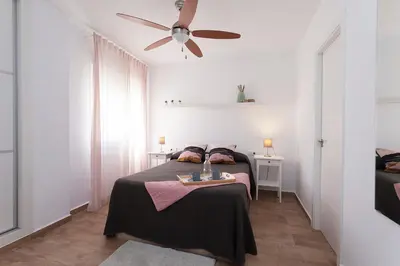 a bedroom with a bed and a ceiling fan at APARTAMENTO VIRGEN DEL CARMEN in Chipiona