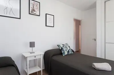 a small bedroom with a bed and a chair at APARTAMENTO VIRGEN DEL CARMEN in Chipiona