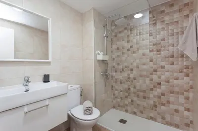 a bathroom with a toilet and a sink and a shower at APARTAMENTO VIRGEN DEL CARMEN in Chipiona