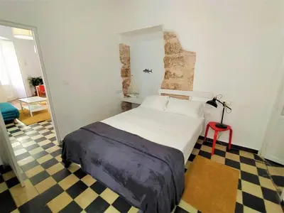 a large bed in a room with a checkered floor at Sol de Cádiz in Cádiz