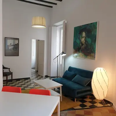 a living room with a blue couch and a table at Sol de Cádiz in Cádiz
