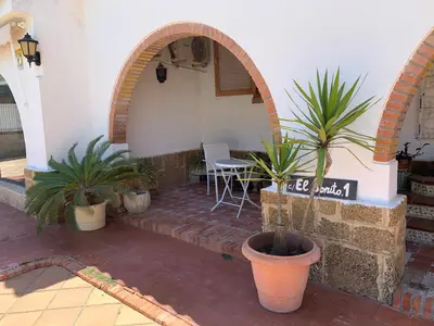 a dog laying on the ground in front of a building at La Quinta - La Barrosa in Chiclana de la Frontera