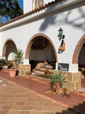 a patio with chairs and a table in a building at La Quinta - La Barrosa in Chiclana de la Frontera