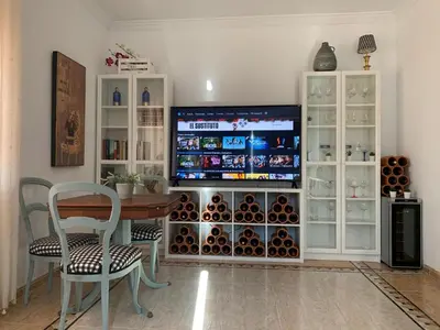 a entertainment center with a television and a table and chairs at La Quinta - La Barrosa in Chiclana de la Frontera