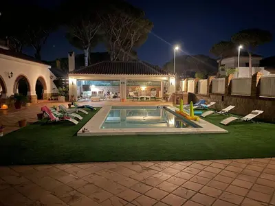 a backyard with a swimming pool and lounge chairs at La Quinta - La Barrosa in Chiclana de la Frontera