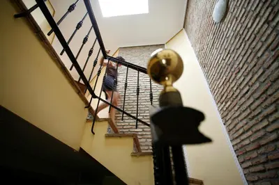 a person walking down a staircase with a person walking up the stairs at Duplex 6 pax con Wifi en Bahia Sur con parking y piscinas comunitarias in San Fernando
