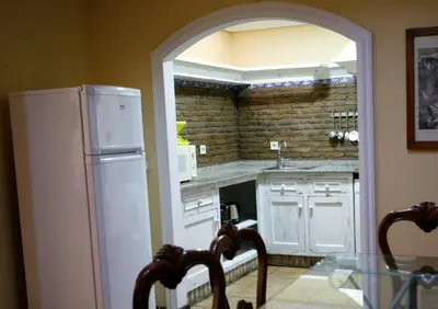 a kitchen with a white refrigerator and a table with chairs at Duplex 6 pax con Wifi en Bahia Sur con parking y piscinas comunitarias in San Fernando