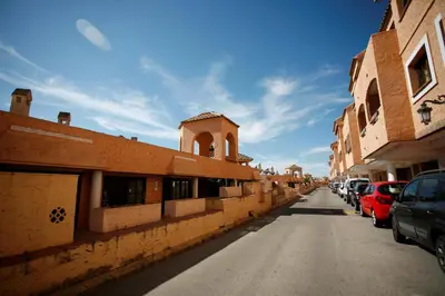 a street with cars parked on the side of a building at Duplex 6 pax con Wifi en Bahia Sur con parking y piscinas comunitarias in San Fernando