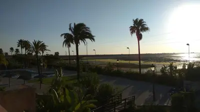 a view of a beach with palm trees and the ocean at Duplex 6 pax con Wifi en Bahia Sur con parking y piscinas comunitarias in San Fernando