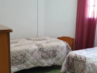 a bedroom with two beds and a window with curtains at Pinar de Don Jesus Sagitario in Campano