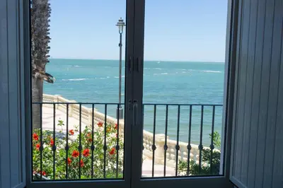 a window view of the ocean from a house at Magnífico alojamiento a 3 metros de la playa y en la Plaza del Castillo in Chipiona