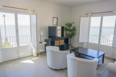 a living room with a table and chairs at Magnífico alojamiento a 3 metros de la playa y en la Plaza del Castillo in Chipiona