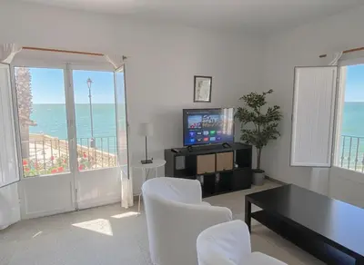 a living room with a television and a table and chairs at Magnífico alojamiento a 3 metros de la playa y en la Plaza del Castillo in Chipiona