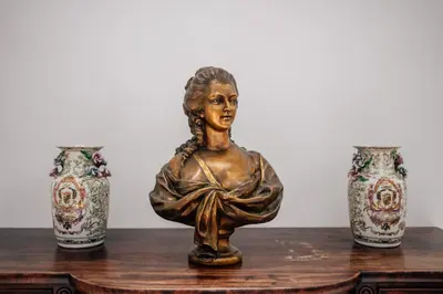 a bronze statue of a woman sitting on a table with three vases at Hotel Boutique Palacio Corredera in Jerez de la Frontera