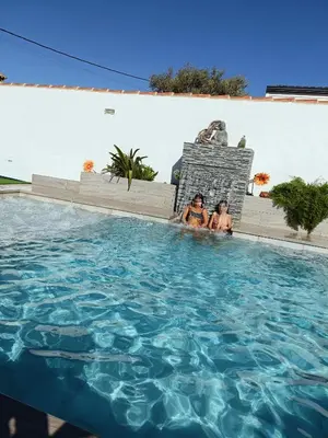 two women are sitting in a swimming pool at Mint House in Chiclana de la Frontera