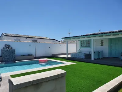 a backyard with a swimming pool and a house at Mint House in Chiclana de la Frontera