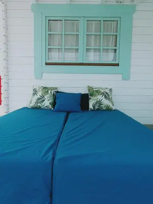 a blue bed with two pillows and a window at Mint House in Chiclana de la Frontera
