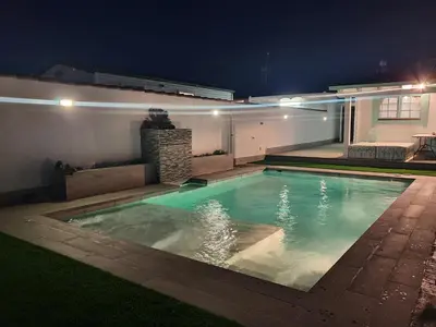 a swimming pool in a backyard at night at Mint House in Chiclana de la Frontera