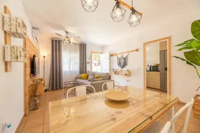 a dining room and living room with a table at Apartamento Playa La Barrosa in Chiclana de la Frontera