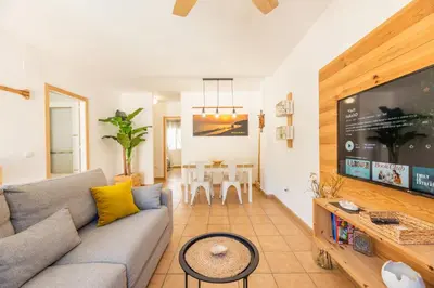 a living room with a couch and a flat screen tv at Apartamento Playa La Barrosa in Chiclana de la Frontera