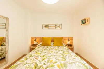 a bedroom with a large bed with yellow pillows at Apartamento Playa La Barrosa in Chiclana de la Frontera