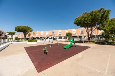 a playground with a slide and a swing at Apartamento Playa La Barrosa in Chiclana de la Frontera