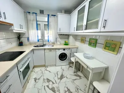 a white kitchen with a sink and a washing machine at GATU PREMIUM Villa Isabel TERRAZA,PARKING,1ºLINEA PLAYA,WIFI,VISTA AL MAR in Cádiz
