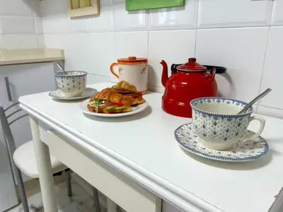 a table with two cups and a plate of food at GATU PREMIUM Villa Isabel TERRAZA,PARKING,1ºLINEA PLAYA,WIFI,VISTA AL MAR in Cádiz