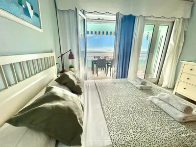 a bedroom with a large bed with a view of the ocean at GATU PREMIUM Villa Isabel TERRAZA,PARKING,1ºLINEA PLAYA,WIFI,VISTA AL MAR in Cádiz