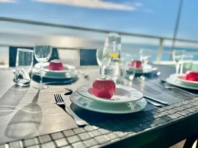 a table with a plate with an apple on it at GATU PREMIUM Villa Isabel TERRAZA,PARKING,1ºLINEA PLAYA,WIFI,VISTA AL MAR in Cádiz