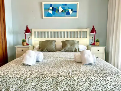 a bedroom with a bed with two pillows on it at GATU PREMIUM Villa Isabel TERRAZA,PARKING,1ºLINEA PLAYA,WIFI,VISTA AL MAR in Cádiz