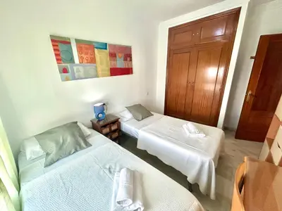 a room with two beds and a door at GATU PREMIUM Villa Isabel TERRAZA,PARKING,1ºLINEA PLAYA,WIFI,VISTA AL MAR in Cádiz