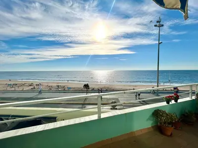 a view of a beach and the ocean with people at GATU PREMIUM Villa Isabel TERRAZA,PARKING,1ºLINEA PLAYA,WIFI,VISTA AL MAR in Cádiz