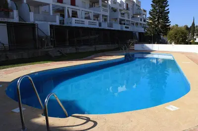 a large blue swimming pool in front of a building at El Anfitrión - Mirador de los Navegantes in Sanlúcar de Barrameda