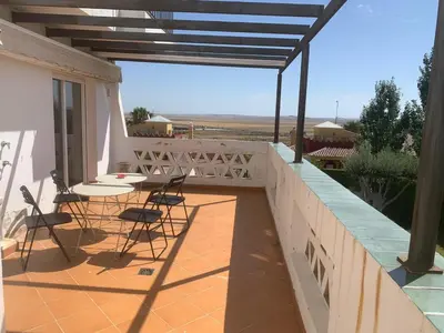 a patio with a table and chairs on a balcony at El Anfitrión - Mirador de los Navegantes in Sanlúcar de Barrameda