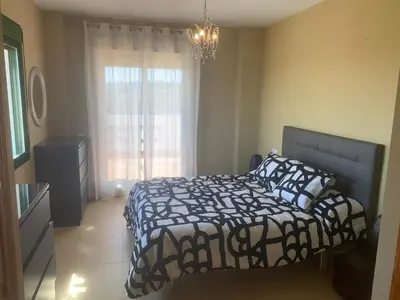 a bedroom with a black and white bed and a window at El Anfitrión - Mirador de los Navegantes in Sanlúcar de Barrameda