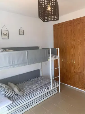 a bedroom with a bunk bed and a wooden cabinet at El Anfitrión - Mirador de los Navegantes in Sanlúcar de Barrameda